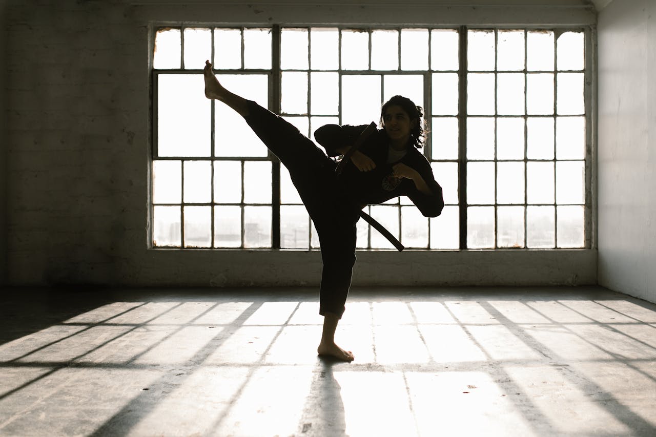 Mastering the First Impression: Your intriguing post title goes here Martial artist performing a high kick in a sunlit room creating dramatic shadows.